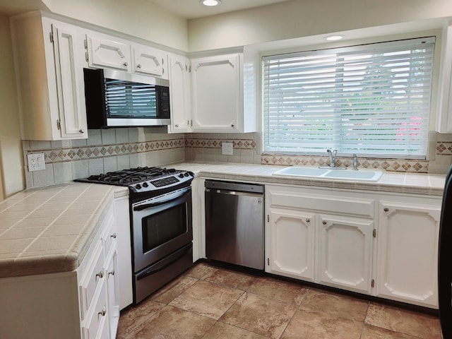 1855 Dennis Ave, Clovis, CA 93611 - kitchen featuring tile counters, a sink, white cabinets, and stainless steel appliances