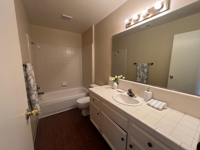 full bathroom with toilet, hardwood / wood-style floors, vanity, and  shower combination