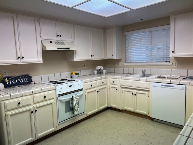 kitchen featuring white cabinetry, sink, white appliances, and tile countertops