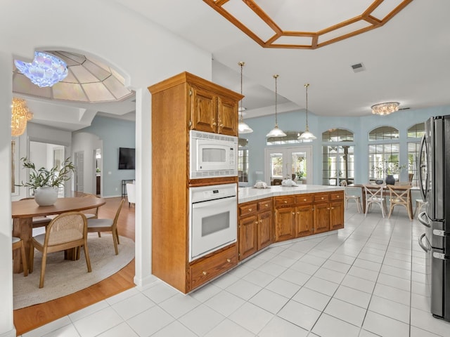 6702 N Langley Ave, Clovis, CA 93619 - kitchen with visible vents, light tile patterned floors, light countertops, white appliances, and brown cabinets