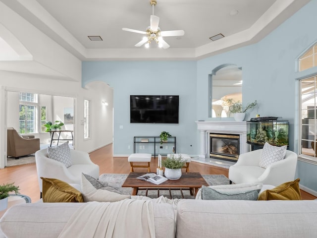 6702 N Langley Ave, Clovis, CA 93619 - living room featuring baseboards, a raised ceiling, a ceiling fan, wood finished floors, and a glass covered fireplace
