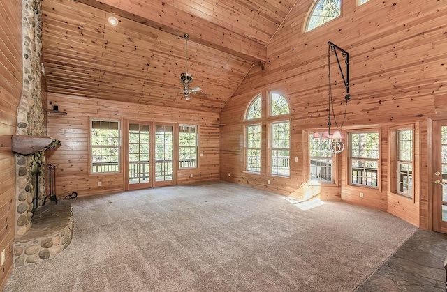 unfurnished living room featuring wooden ceiling, a fireplace, carpet floors, and wood walls