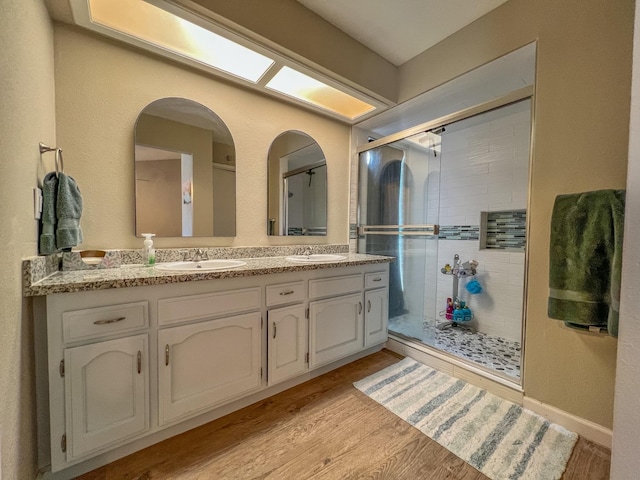 bathroom featuring vanity, hardwood / wood-style flooring, and a shower with shower door