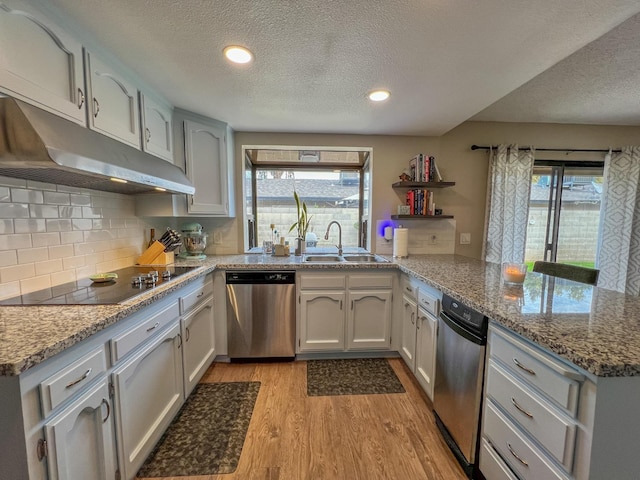 kitchen featuring sink, black electric cooktop, dishwasher, kitchen peninsula, and light hardwood / wood-style floors