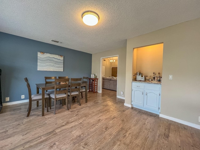 dining room featuring light hardwood / wood-style floors and a textured ceiling