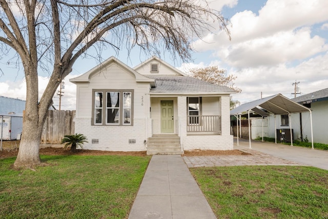 bungalow-style home with a carport, central AC unit, and a front yard