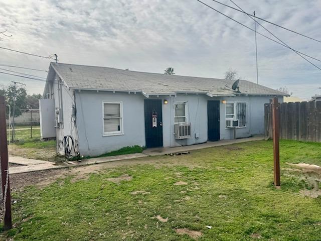 back of property with cooling unit and a yard