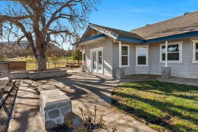 view of side of property featuring a patio and fence