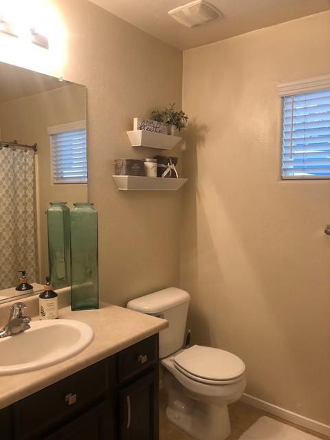 bathroom featuring vanity, tile patterned flooring, and toilet