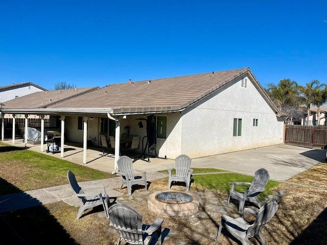 back of property featuring a patio area and an outdoor fire pit