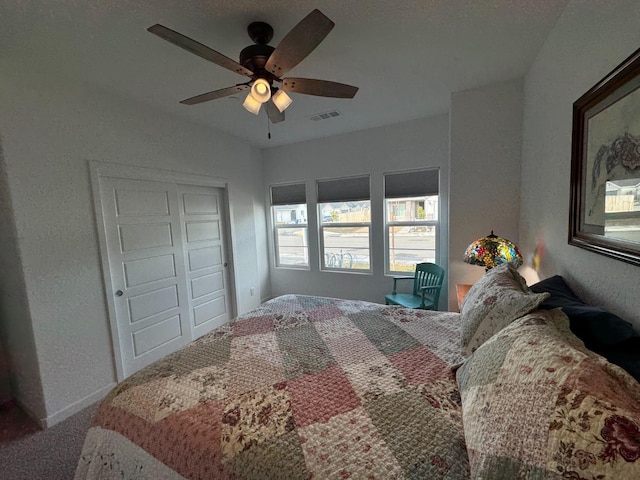 carpeted bedroom with ceiling fan and a closet