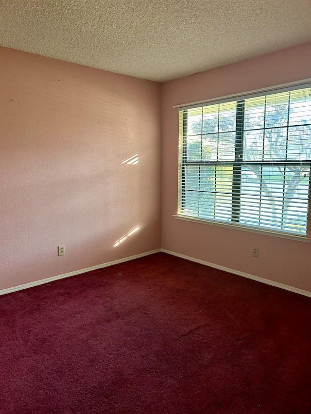 carpeted spare room with a textured ceiling