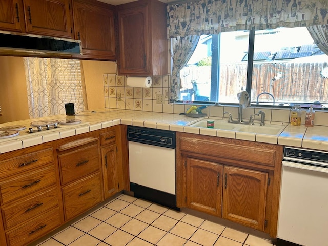 kitchen featuring ventilation hood, tasteful backsplash, sink, and tile countertops