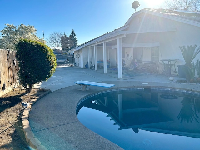 view of pool featuring a diving board and a patio area