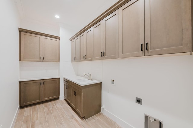 washroom featuring sink, crown molding, electric dryer hookup, cabinets, and washer hookup