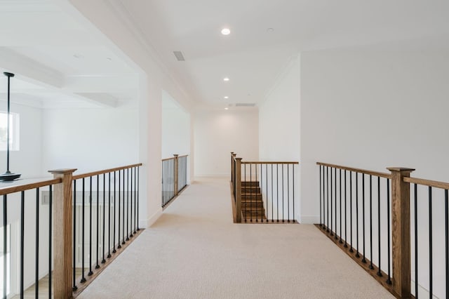 corridor with beam ceiling, crown molding, coffered ceiling, and light colored carpet