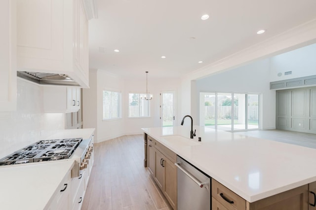 kitchen featuring a spacious island, sink, ornamental molding, stainless steel appliances, and backsplash