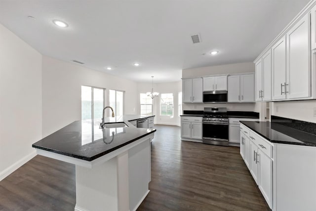 kitchen featuring sink, appliances with stainless steel finishes, hanging light fixtures, an island with sink, and white cabinets