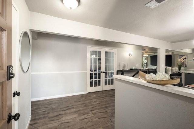 foyer entrance featuring french doors, a ceiling fan, baseboards, dark wood-type flooring, and visible vents