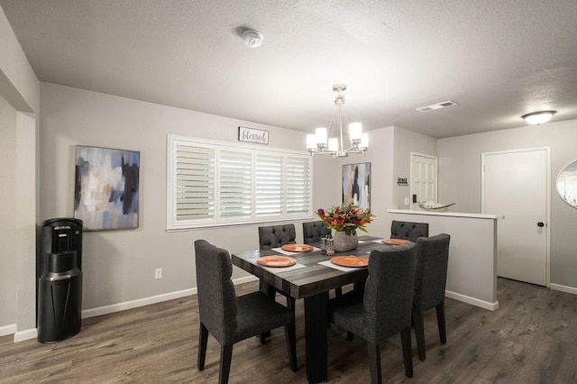 dining room featuring wood finished floors, baseboards, a chandelier, and visible vents