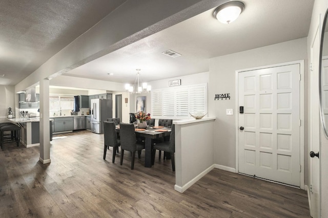 dining space featuring baseboards, a notable chandelier, dark wood-style floors, and visible vents
