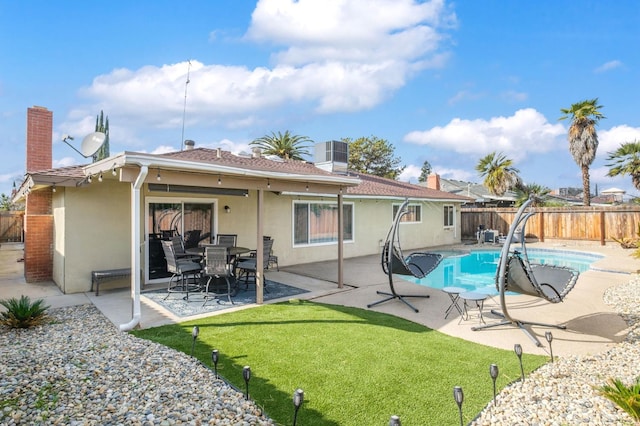 rear view of property featuring a fenced backyard, a patio area, stucco siding, and a yard