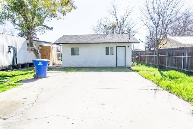 rear view of house with stucco siding and fence