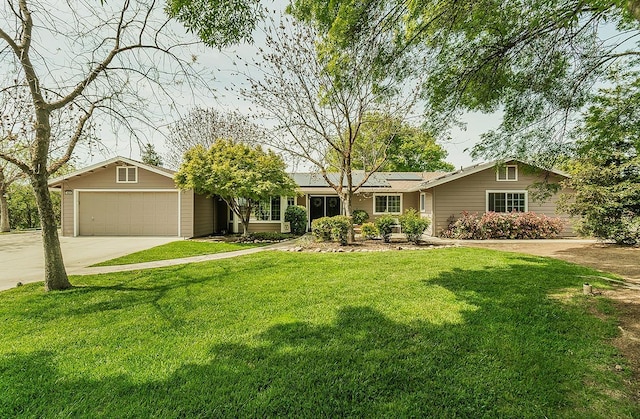 16526 Paula Rd, Madera, CA 93636 - single story home featuring concrete driveway, a garage, solar panels, and a front yard