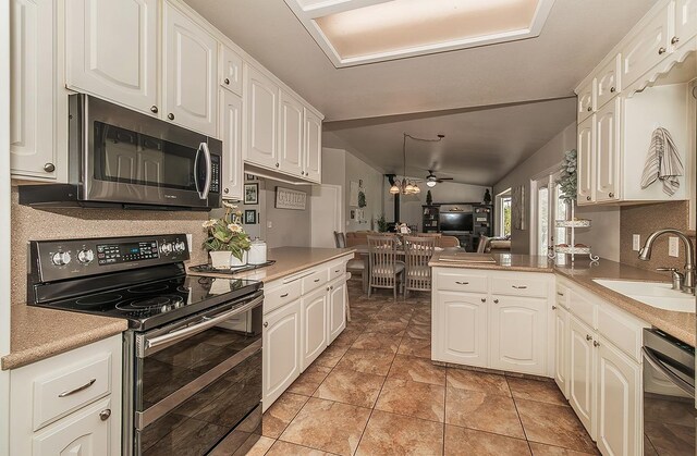 16526 Paula Rd, Madera, CA 93636 - kitchen with a sink, open floor plan, appliances with stainless steel finishes, a peninsula, and white cabinetry