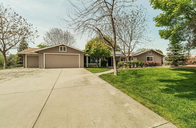 16526 Paula Rd, Madera, CA 93636 - ranch-style home with a garage, a front yard, concrete driveway, and solar panels