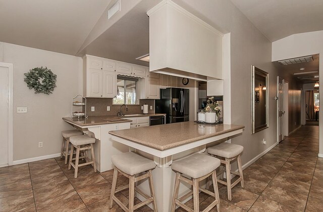16526 Paula Rd, Madera, CA 93636 - kitchen with tasteful backsplash, visible vents, a peninsula, black appliances, and a breakfast bar area