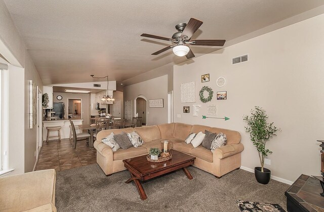 16526 Paula Rd, Madera, CA 93636 - carpeted living room featuring lofted ceiling, a textured ceiling, visible vents, ceiling fan, and arched walkways