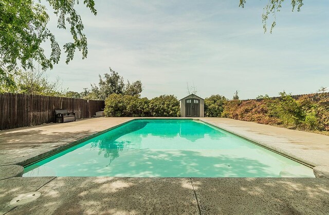 16526 Paula Rd, Madera, CA 93636 - view of pool with a fenced in pool, a shed, a patio area, an outbuilding, and fence