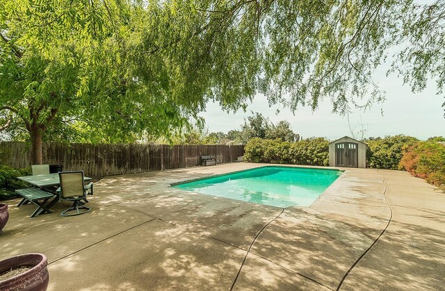 16526 Paula Rd, Madera, CA 93636 - view of pool with a patio area, a fenced backyard, an outdoor structure, and a storage unit