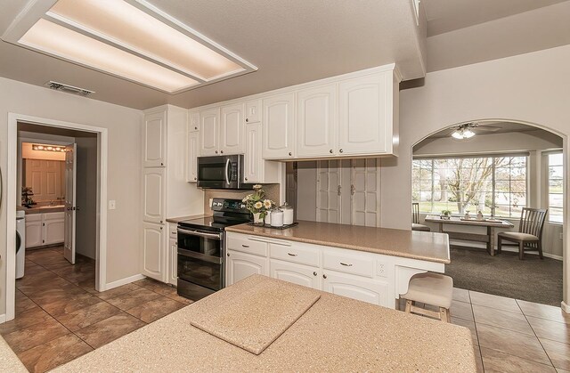 16526 Paula Rd, Madera, CA 93636 - kitchen featuring white cabinets, washer / dryer, visible vents, stainless steel appliances, and arched walkways