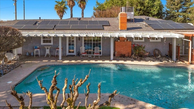 view of swimming pool with cooling unit and a patio