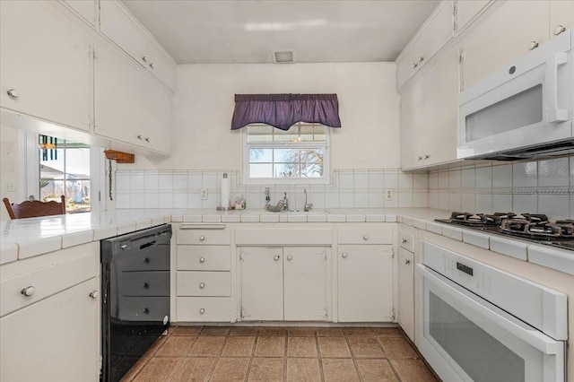 kitchen featuring white cabinetry, tile countertops, and white appliances