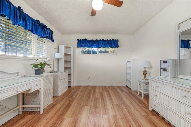 unfurnished office featuring ceiling fan, a textured ceiling, and light wood-type flooring