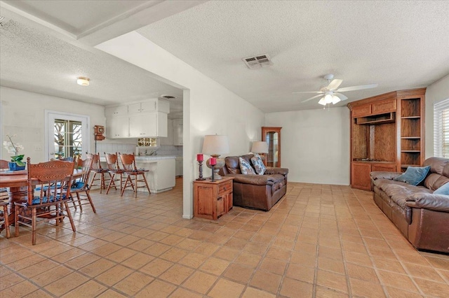 living room featuring a textured ceiling and ceiling fan