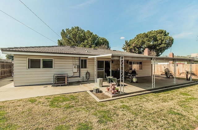 back of property featuring a patio area and a lawn