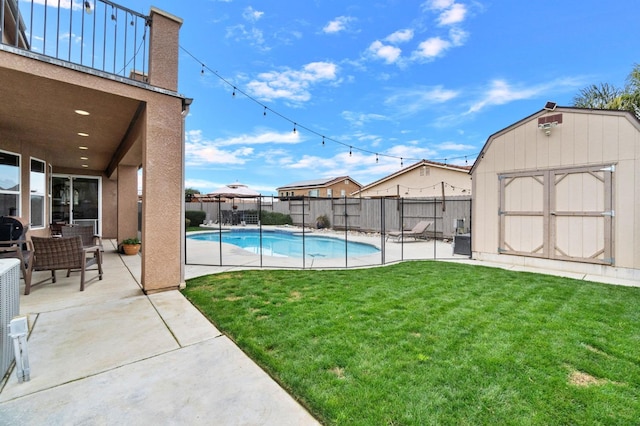 view of swimming pool featuring a yard, a patio, and a storage unit