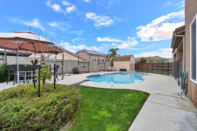 view of pool with a mountain view, a patio area, and a storage unit