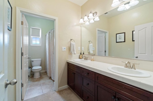 bathroom with vanity, tile patterned flooring, and toilet