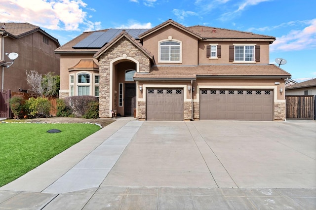 view of front of home with a garage, a front lawn, and solar panels