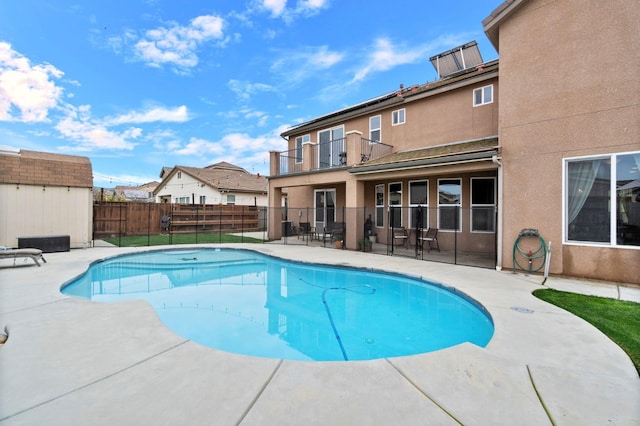 view of swimming pool with a patio and a shed