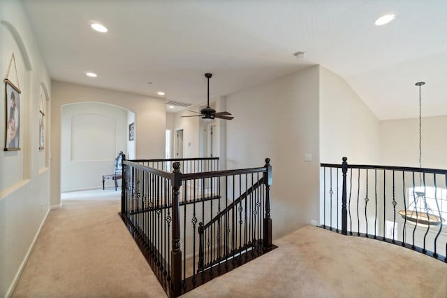 hall featuring vaulted ceiling and light colored carpet