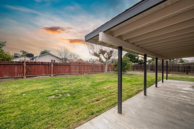 yard at dusk featuring a patio and a fenced backyard