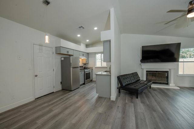 kitchen with appliances with stainless steel finishes, open floor plan, visible vents, gray cabinets, and vaulted ceiling