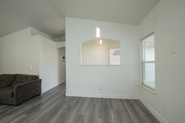 living room featuring baseboards, vaulted ceiling, and light wood-style flooring