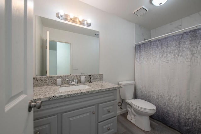 bathroom with vanity, wood finished floors, visible vents, curtained shower, and toilet